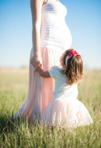 Мать и дочка в светлых платьях в пшеничном поле